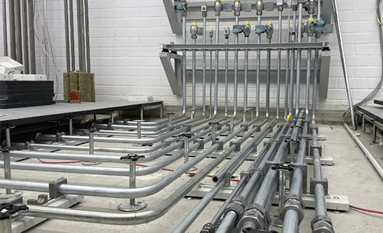 Hydraulische Rohrleitungen und Verteiler einer Industrieanlage während der Verrohrungsarbeiten.