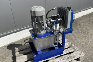Hydraulikaggregat mit Elektromotor und Hydraulikpumpe auf Industriepalette.