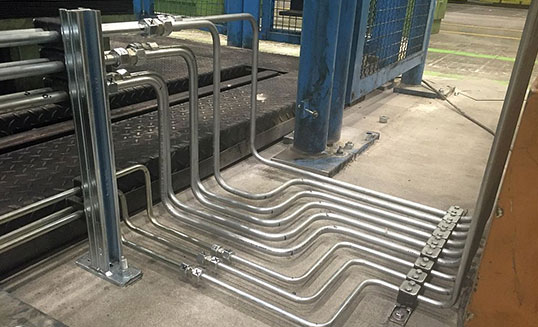 Präzise gebogene Hydraulikrohre an einem Prüfstand als Teil einer industriellen Hydraulikverrohrung.