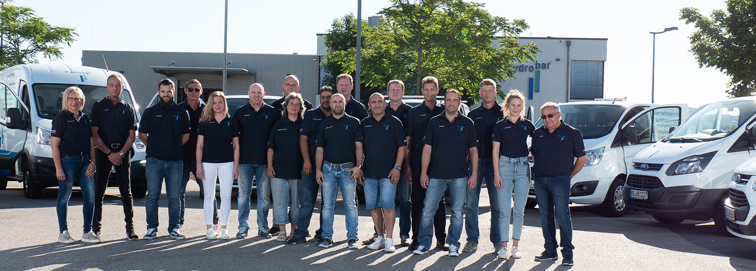 Hydrobar Team vor Firmengebäude und Servicefahrzeugen für Hydraulik Service