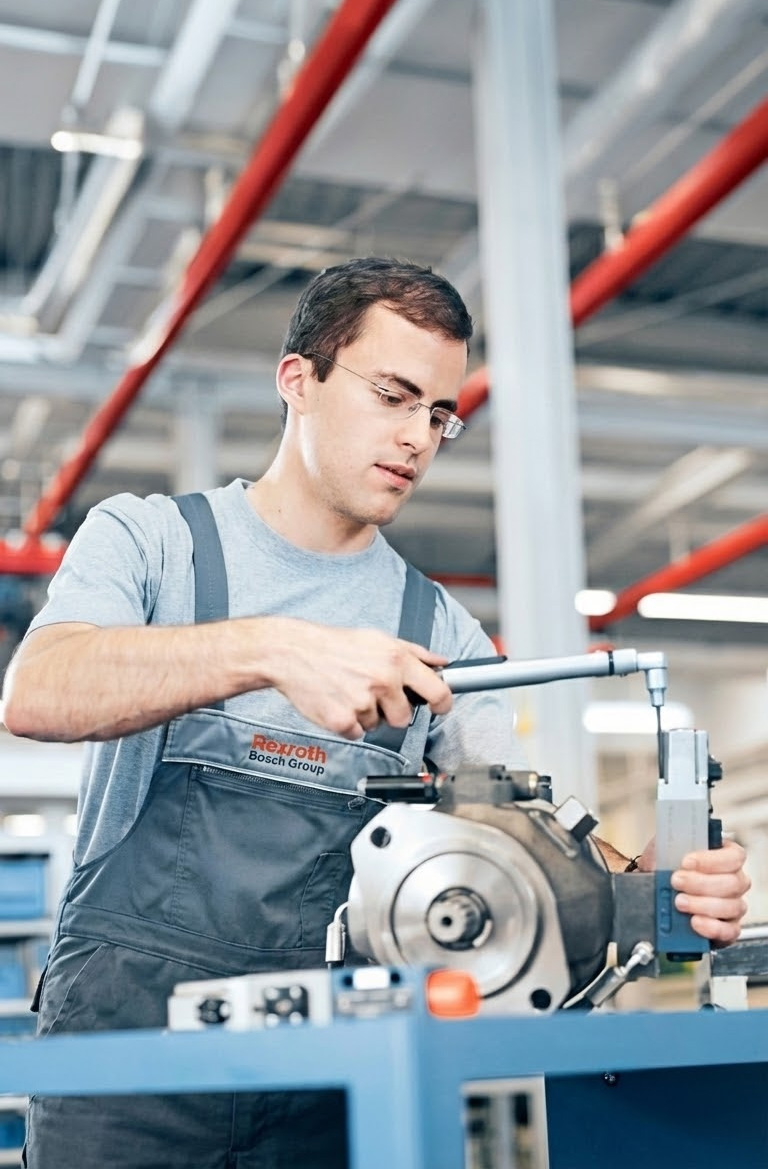 Servicetechniker arbeitet an einer Hydraulikkomponente als Bosch Rexroth Partner im Industriebereich.