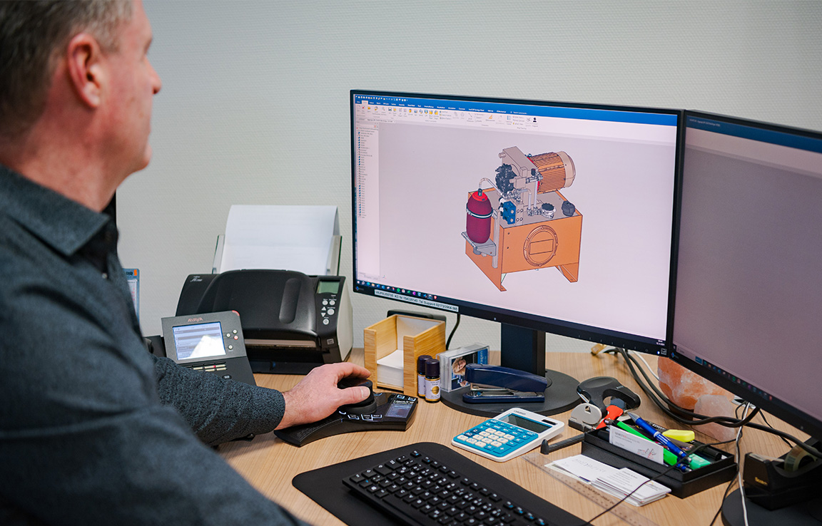 Ingenieur plant Hydraulikaggregat in CAD-Software am Computer.